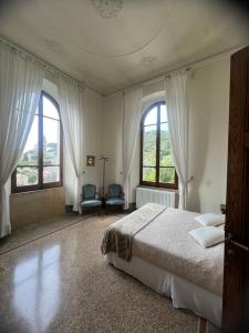 ein Schlafzimmer mit einem Bett und zwei Fenstern in der Unterkunft Villa Paolo Lemon Tree in Porto Venere