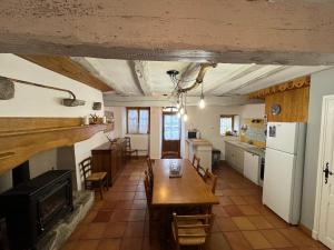 a kitchen and dining room with a table and a fireplace at Agréable maison de village au cœur de Sarrancolin in Sarrancolin