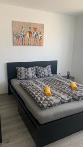 Una cama con dos almohadas amarillas encima. en New Home Guest House en Gödöllő
