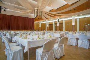 a banquet hall with white tables and chairs at Hotel Schuetzenhaus Vorsfelde in Wolfsburg