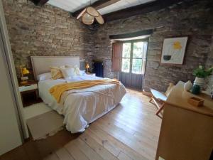 a bedroom with a large bed and a brick wall at La Escondida in Caboalles de Abajo