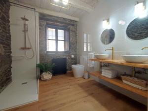 a large bathroom with two sinks and a shower at La Escondida in Caboalles de Abajo