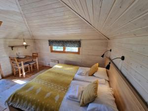 Cama grande en habitación de madera con mesa en Reindeer Lodge, en Jukkasjärvi