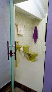 a bathroom with a yellow toilet and a sink at Departamento 1 casa Iglesias in Sucre
