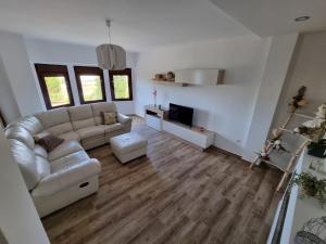 sala de estar con sofá y TV en Villa La Escollera Ronda en Arriate
