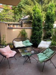 un patio con 2 sillas y una mesa con almohadas en Apartman Meri, en Sarajevo