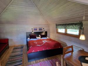 Un dormitorio con una cama roja en una habitación pequeña. en Reindeer Lodge, en Jukkasjärvi