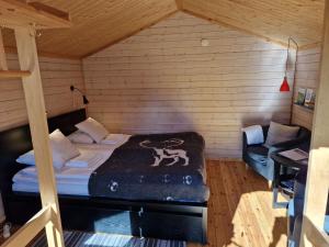 um quarto com uma cama e um sofá num quarto em Reindeer Lodge em Jukkasjärvi