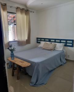 Un dormitorio con una cama azul y una mesa en Casa de Irene en Cabo Frío