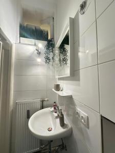 a white bathroom with a sink and a mirror at Ferienwohnung Marion Klagenfurt zentrumsnähe in Klagenfurt