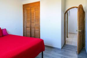 Depa - a 3 min del CAS VISA USA Consulado في Heroica Nogales: غرفة نوم بسرير احمر وباب خشبي