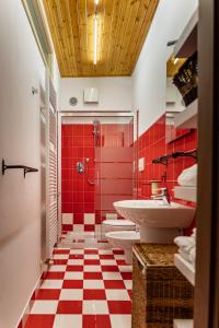 La salle de bains est pourvue de 2 lavabos et d'un sol en damier rouge et blanc. dans l'établissement Magico Loft nel Centro Storico, à Toscolano Maderno