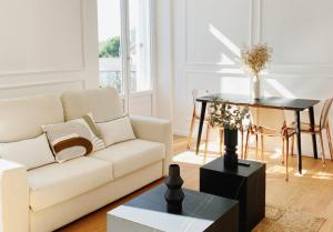 sala de estar con sofá blanco y mesa en Le Haussmann ⸱ Stationnement gratuit ⸱ Fibre, en Déols