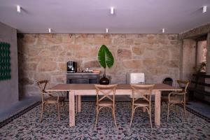 uma sala de jantar com uma mesa de madeira e cadeiras em Quinta de São Francisco Houses em Viseu