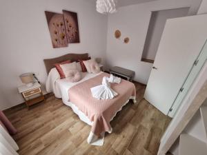 Villa La Escollera Ronda في أرياتي: غرفة نوم بسرير وبطانية وردية