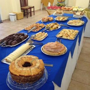 a blue table with pies and other desserts on it at Barrudada Palace Hotel-Boa Vista in Boa Vista