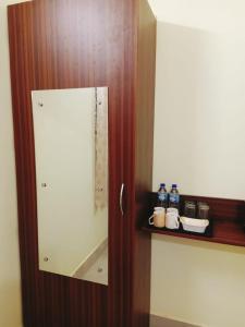 baño con espejo y botellas de agua en un estante en THE STAY CORNER, en Guwahati