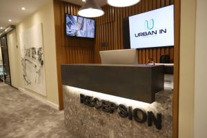 an office with a reception desk with a sign on it at Urbanin Apartment & Hotel in Tirana