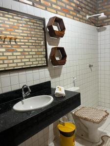 a bathroom with a sink and a toilet at Villa Arpoador in Tutóia