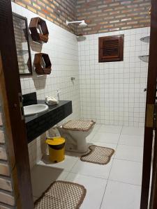 a bathroom with a toilet and a sink at Villa Arpoador in Tutóia