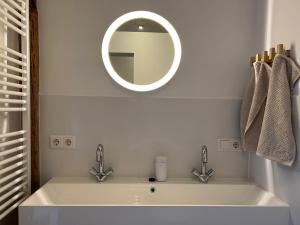 a bathroom with a white sink and a mirror at de Danenberg in Slijk-Ewijk