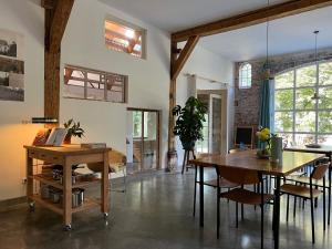 a living room with a dining room table and chairs at de Danenberg in Slijk-Ewijk