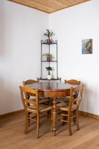 une table en bois avec des chaises et une plante au-dessus dans l'établissement Magico Loft nel Centro Storico, à Toscolano Maderno