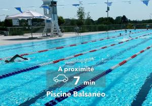 einen Pool mit einem Schwimmer darin in der Unterkunft Le Haussmann ⸱ Stationnement gratuit ⸱ Fibre in Déols