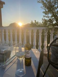 - une bouteille de vin et un verre de vin sur le balcon dans l'établissement Casa Narú Albir, duplex appartement met ruim terras en buitenkeuken, à Albir