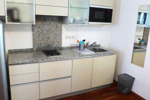 a kitchen with white cabinets and a sink at Schlossquadrat Apartement 14 A in Vienna