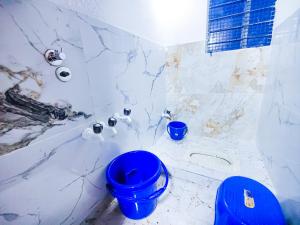 een badkamer met een blauw toilet en een bad bij Sahara Family Homestay in Mysore