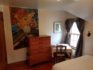 una camera da letto con cassettiera e un dipinto sul muro di 1936 Art & International Home a Lancaster