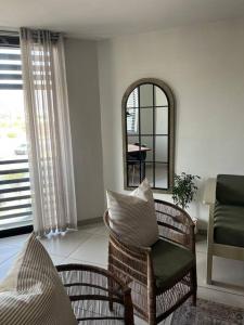 - un salon avec une chaise et un miroir dans l'établissement Wild Olive 91, à Windhoek