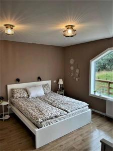 a bedroom with a large bed in a room with a window at Greenhouse Golden Circle Villa in Reykholt