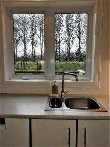 a kitchen counter with a sink and a window at Greenhouse Golden Circle Villa in Reykholt