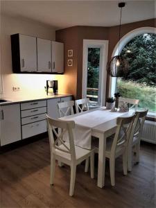 a kitchen with a white table and white chairs at Greenhouse Golden Circle Villa in Reykholt