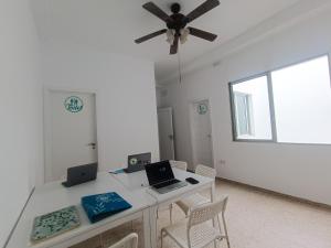 a white room with a desk with a laptop on it at Daydream Medano Coliving in El Médano