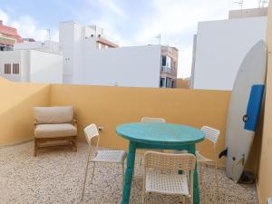 a table and chairs on a balcony with a surfboard at Daydream Medano Coliving in El Médano
