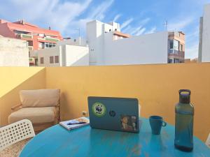 a laptop sitting on a table with a bottle at Daydream Medano Coliving in El Médano