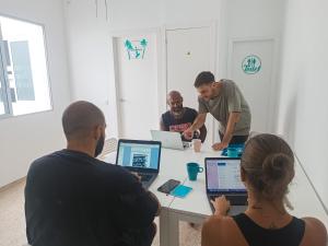 a group of people sitting around a table with laptops at Daydream Medano Coliving in El Médano