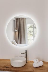 a bathroom with a white sink and a mirror at HOSTAL XUROY in Sant Lluis