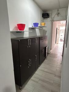 a kitchen with black cabinets and colorful bowls on the counter at Hostel Quinta Camacho in Bogotá