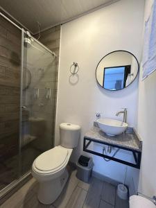 ein Badezimmer mit einem WC, einem Waschbecken und einem Spiegel in der Unterkunft Hostel Quinta Camacho in Bogotá