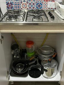 a kitchen drawer with a stove and pots and pans at Hostel Quinta Camacho in Bogotá