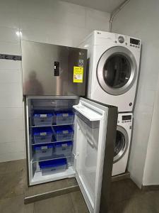 a refrigerator with its door open next to a washing machine at Hostel Quinta Camacho in Bogotá