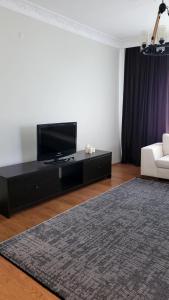 ein Wohnzimmer mit einem Flachbild-TV und einem Sofa in der Unterkunft 3+1 Bağdat Caddesine yakın in Istanbul