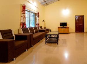 a large living room with couches and a tv at Royal Nest Villa in Mahabaleshwar