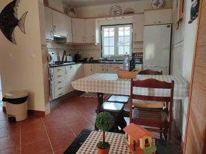 a kitchen with a table and a table and a house on it at A casa do Almograve in Almograve