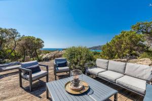 un patio con un divano, 2 sedie e un tavolo di Villa Sud Corse 6ch piscine 27m, accès mer a Pianottoli-Caldarello Altre 3 foto