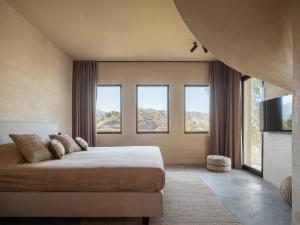 Un dormitorio con una cama y un televisor y ventanas. en Villa Rocca, en La Herradura 30 fotos más